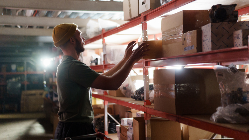A person stacking boxes in a warehouse