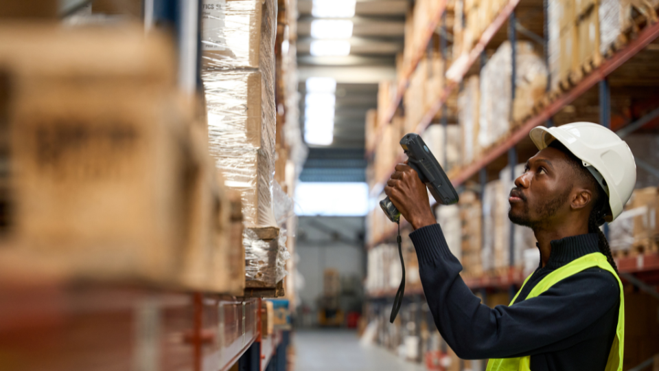 A person using a handheld scanner in a warehouse